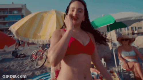 A Woman In A Red Bikini Is On The Beach GIF