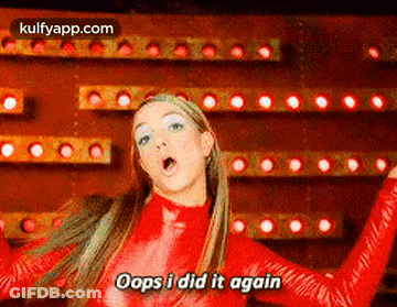 A Woman In A Red Bodysuit Is Dancing In Front Of A Wall Of Lights . GIF