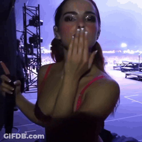 A Woman In A Red Bra Is Blowing A Kiss With A Purple Background GIF
