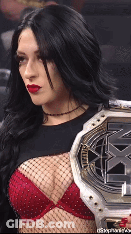A Woman In A Red Bra Is Holding A X-Match Championship Belt GIF