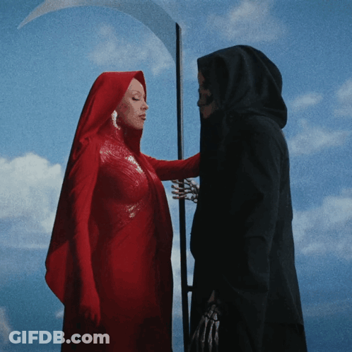 A Woman In A Red Cape Stands Next To A Grim Reaper With A Scythe GIF