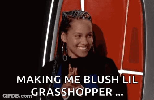 A Woman In A Red Chair Is Smiling And Making A Funny Face . GIF