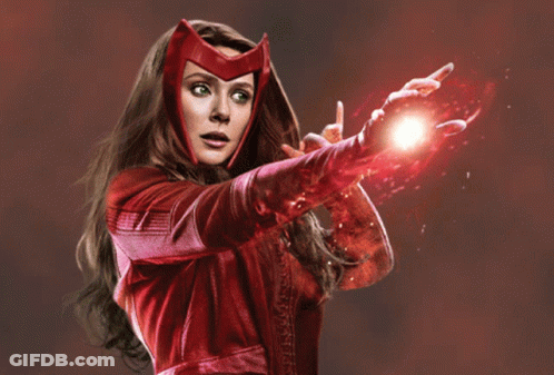 A Woman In A Red Costume Is Holding A Red Object In Her Hand GIF