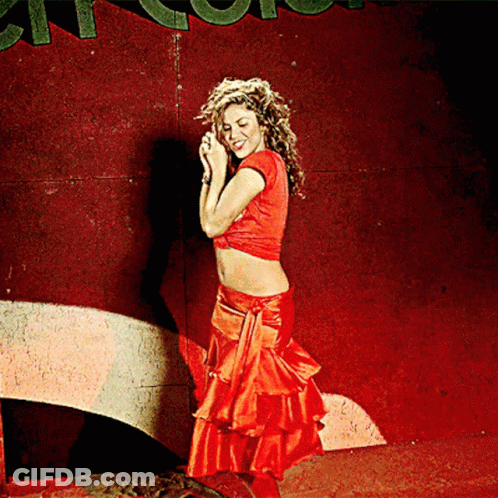 A Woman In A Red Crop Top And Red Skirt Stands In Front Of A Sign That Says ' A ' On It GIF