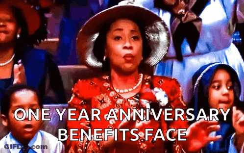 A Woman In A Red Dress And Hat Is Sitting In A Crowd And Says One Year Anniversary Benefits Face .. GIF