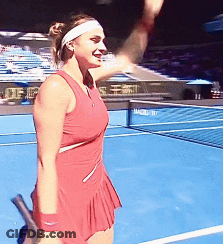 A Woman In A Red Dress Holds A Tennis Racquet On A Tennis Court GIF