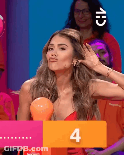 A Woman In A Red Dress Holds Her Hand To Her Ear Behind A Sign That Says 4 GIF