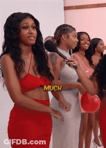 A Woman In A Red Dress Is Being Interviewed By A Woman In A Pink Dress GIF