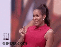A Woman In A Red Dress Is Crying While Sitting In Front Of A Screen . GIF