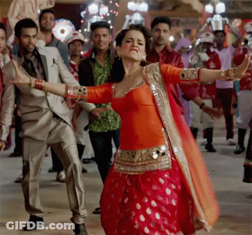 A Woman In A Red Dress Is Dancing In A Crowd GIF