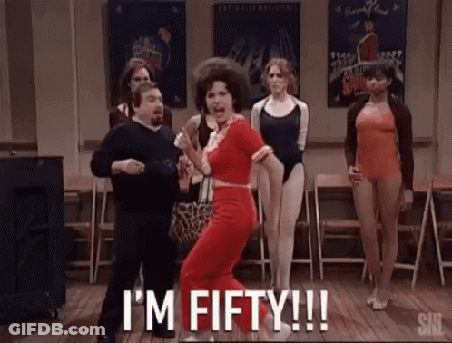A Woman In A Red Dress Is Dancing In A Room With A Group Of Women . GIF