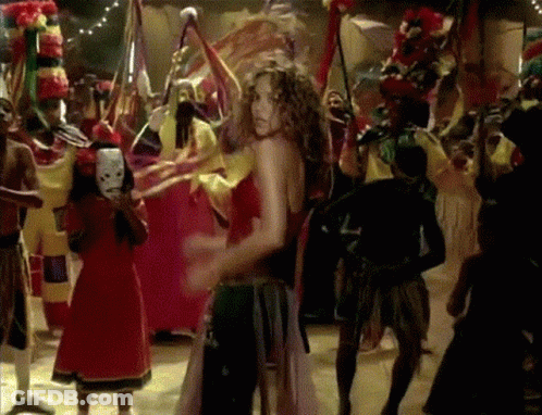 A Woman In A Red Dress Is Dancing In Front Of A Crowd GIF