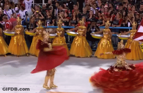 A Woman In A Red Dress Is Dancing In Front Of A Crowd Wearing A Staff Shirt GIF