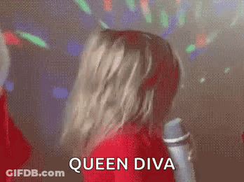 A Woman In A Red Dress Is Dancing In Front Of A Microphone And The Words Queen Diva Are Written On The Screen . GIF