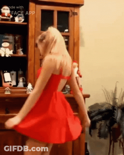 A Woman In A Red Dress Is Dancing In Front Of A Wooden Cabinet Made With The Face App GIF