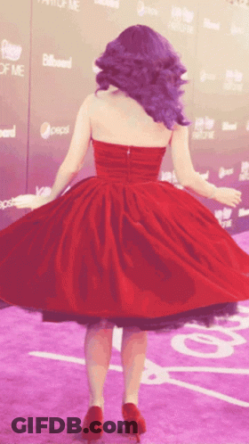 A Woman In A Red Dress Is Dancing On A Purple Carpet In Front Of A Billboard That Says Pepsi GIF