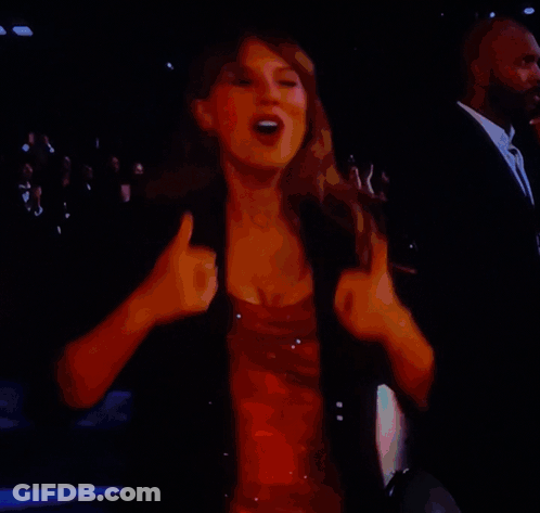A Woman In A Red Dress Is Dancing On A Stage In Front Of A Crowd GIF