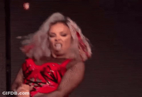A Woman In A Red Dress Is Dancing On A Stage In Front Of A Purple Background . GIF