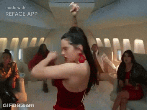 A Woman In A Red Dress Is Dancing On An Airplane While A Group Of People Watch . GIF