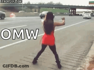 A Woman In A Red Dress Is Dancing On The Side Of A Highway With The Word Omw In White Letters GIF