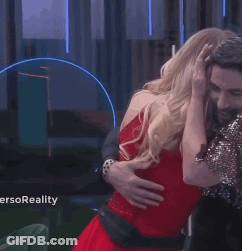 A Woman In A Red Dress Is Dancing With A Man In A Suit And Tie . GIF