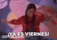 A Woman In A Red Dress Is Dancing With Her Arms Outstretched And The Words `` Ya Es Viernes '' Written Below Her . GIF