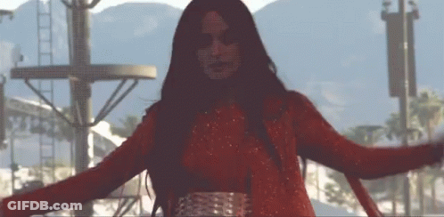 A Woman In A Red Dress Is Dancing With Her Arms Outstretched GIF