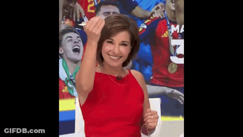 A Woman In A Red Dress Is Giving A Middle Finger In Front Of A Soccer Team . GIF