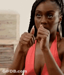 A Woman In A Red Dress Is Giving A Thumbs Up . GIF