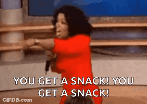 A Woman In A Red Dress Is Holding A Microphone And Saying You Get A Snack You Get A Snack . GIF