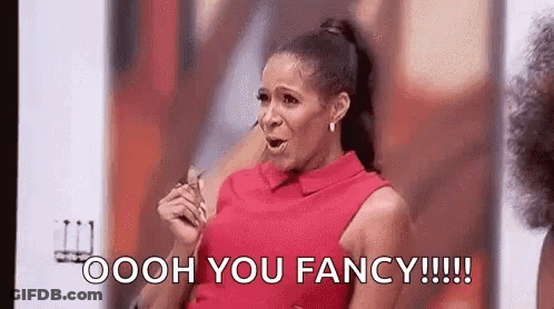 A Woman In A Red Dress Is Holding A Pair Of Glasses And Saying Oooh You Fancy . GIF