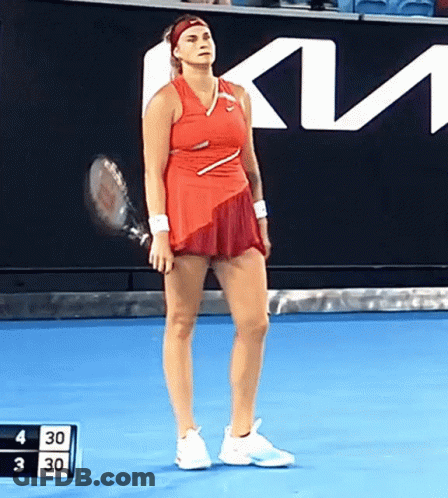 A Woman In A Red Dress Is Holding A Tennis Racket On A Blue Court GIF