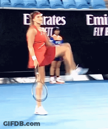 A Woman In A Red Dress Is Holding A Tennis Racquet On A Blue Court GIF