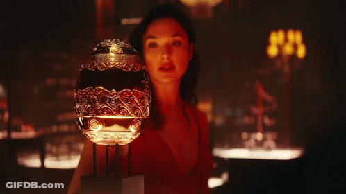 A Woman In A Red Dress Is Holding A Trophy In Her Hands GIF