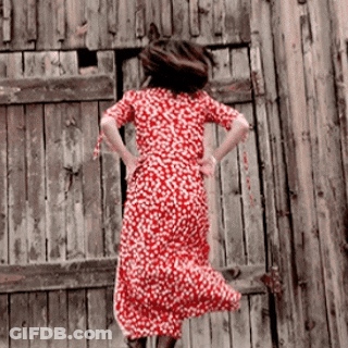 A Woman In A Red Dress Is Jumping In The Air GIF