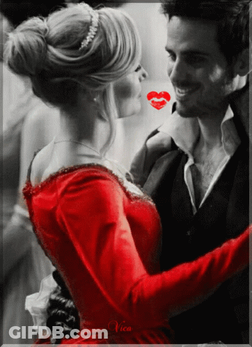 A Woman In A Red Dress Is Kissing A Man In A Black And White Photo GIF