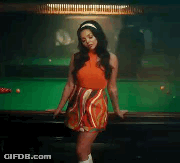 A Woman In A Red Dress Is Leaning On The Edge Of A Pool Table . GIF