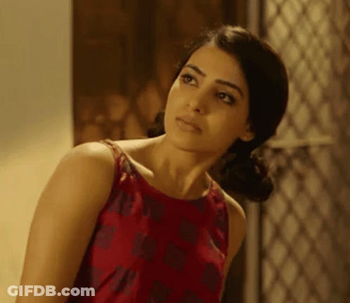 A Woman In A Red Dress Is Looking At Something GIF