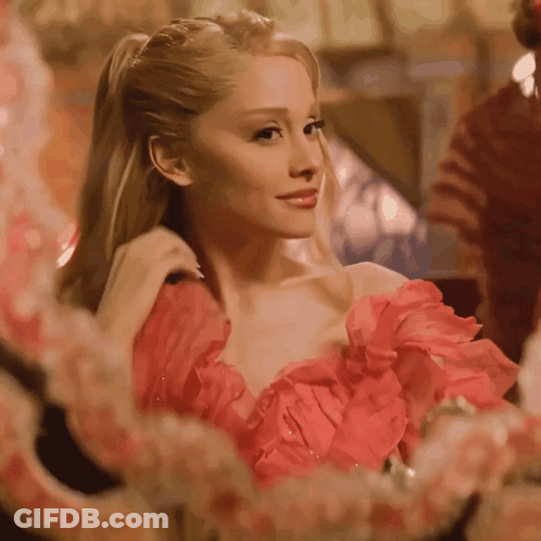 A Woman In A Red Dress Is Looking In A Mirror GIF