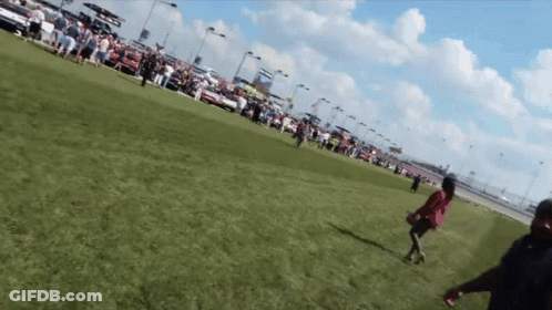A Woman In A Red Dress Is Running In A Field GIF