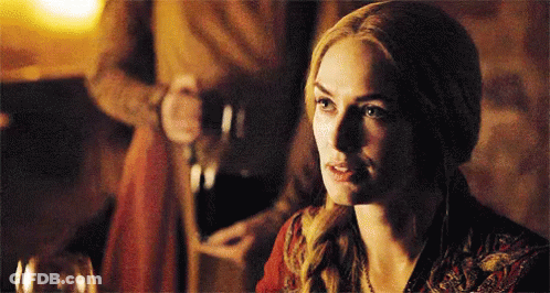 A Woman In A Red Dress Is Sitting At A Table With A Glass Of Wine In Front Of Her . GIF