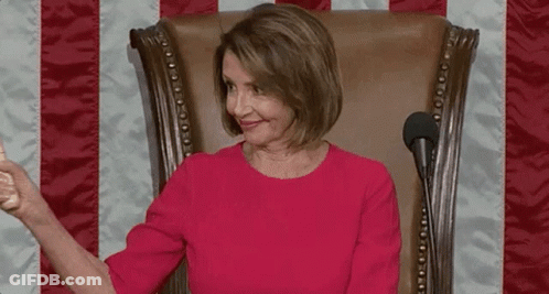 A Woman In A Red Dress Is Sitting In A Chair Holding A Wooden Hammer . GIF