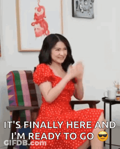 A Woman In A Red Dress Is Sitting In A Chair With Her Hands In The Air And Says It 'S Finally Here GIF