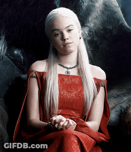 A Woman In A Red Dress Is Sitting In Front Of A Large Animal GIF