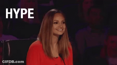 A Woman In A Red Dress Is Sitting In Front Of A Microphone And The Word Hype Is Written On The Screen . GIF