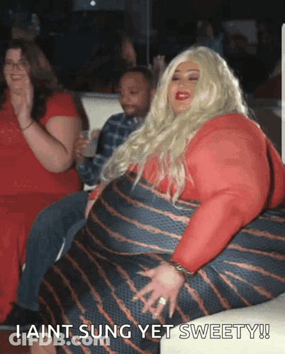 A Woman In A Red Dress Is Sitting On A Couch And Says " I Ain T Sung Yet Sweety " GIF