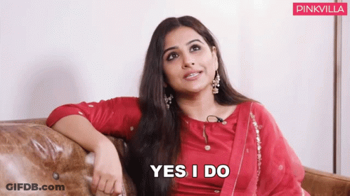 A Woman In A Red Dress Is Sitting On A Couch And Says " Yes I Do " GIF