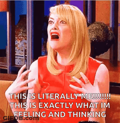 A Woman In A Red Dress Is Sitting On A Couch With Her Mouth Open And Making A Funny Face . GIF