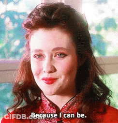 A Woman In A Red Dress Is Smiling And Saying Because I Can Be . GIF