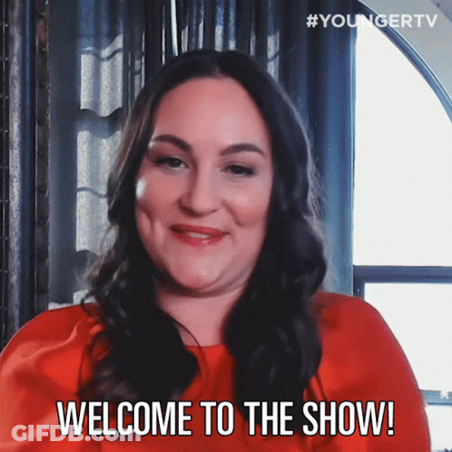 A Woman In A Red Dress Is Smiling And Says Welcome To The Show GIF